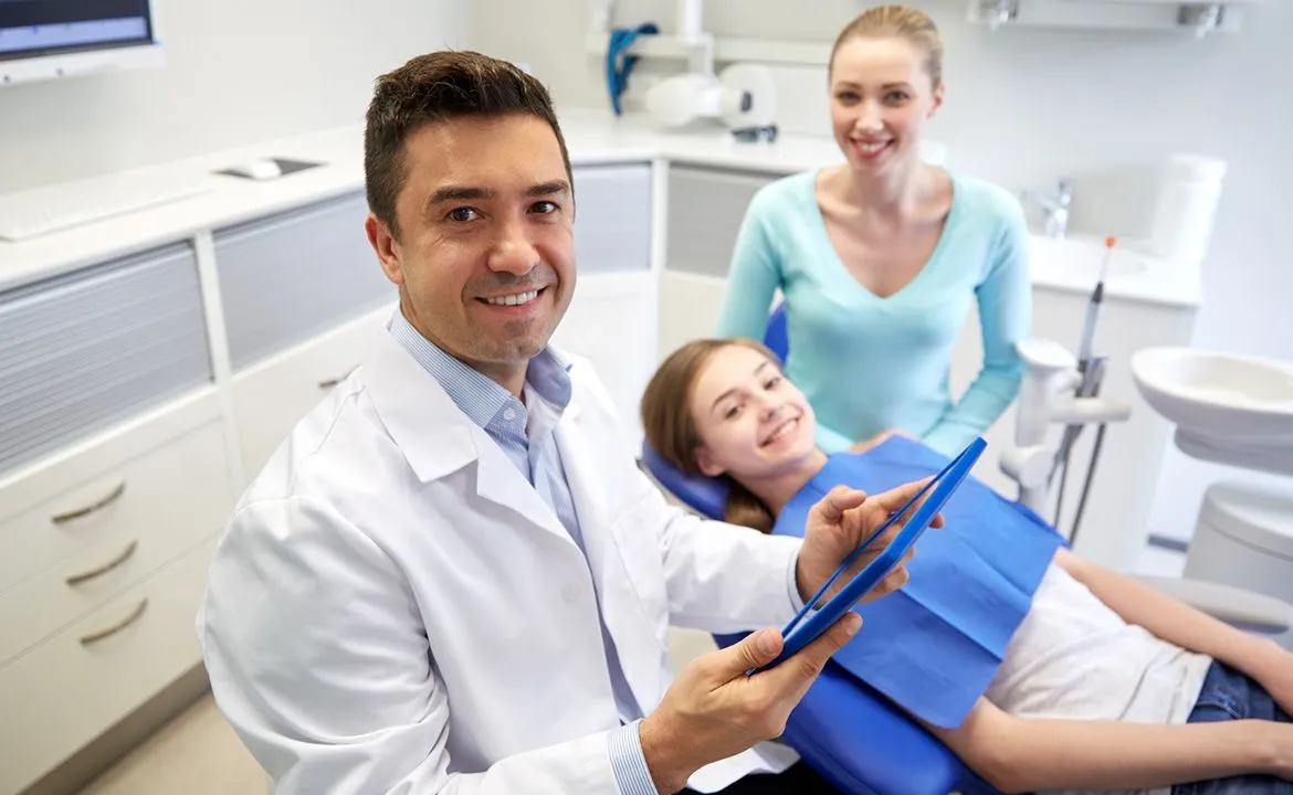 Dentist and young patient smiling in the treatment room